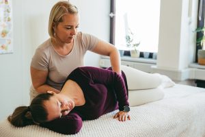 Craniosacral Therapeutin Melissa Jacobs von glücklich aufwachsen bei der craniosacralen Behandlung eines einer Schwangeren Frau