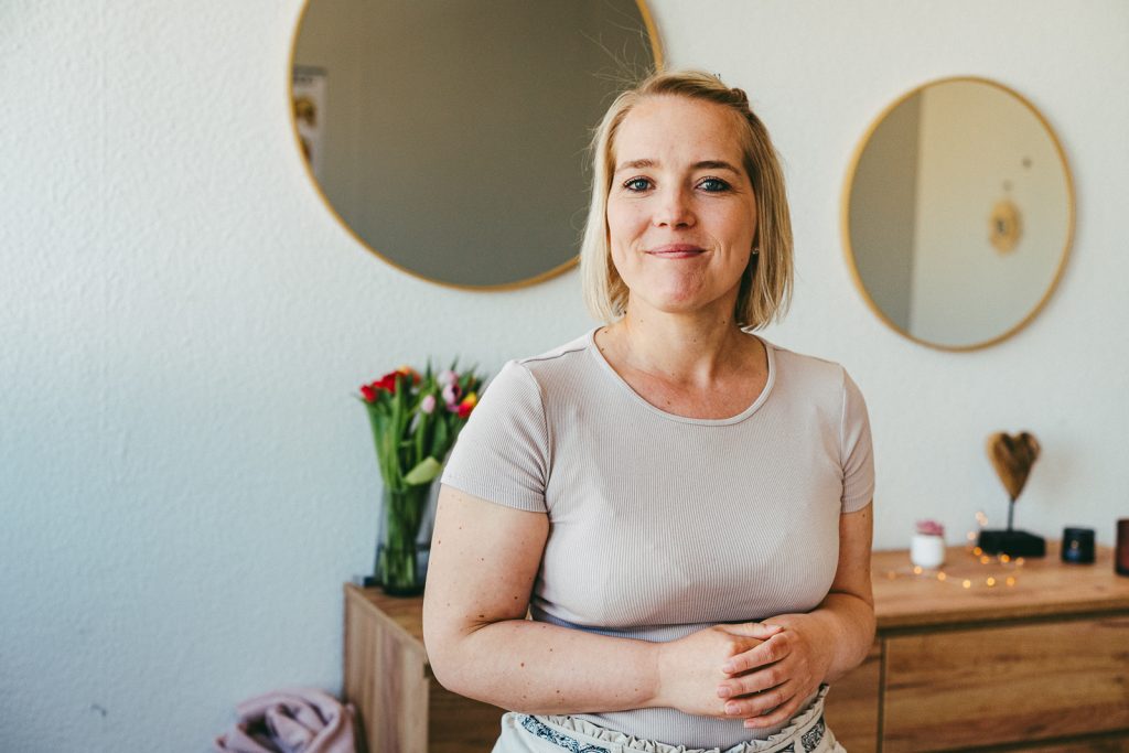 Craniosacral Therapeutin Melissa von glücklich aufwachsen lächelnd in ihrer Praxis stehend